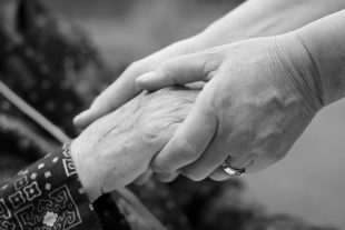 Doctor's hand holding an elderly hand