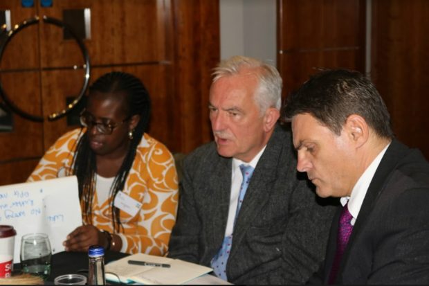 A woman and two men listening to a presentation