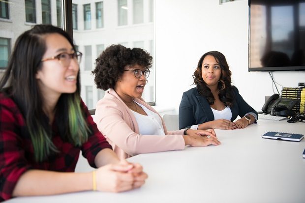 Three women sitting at a table having a conversation