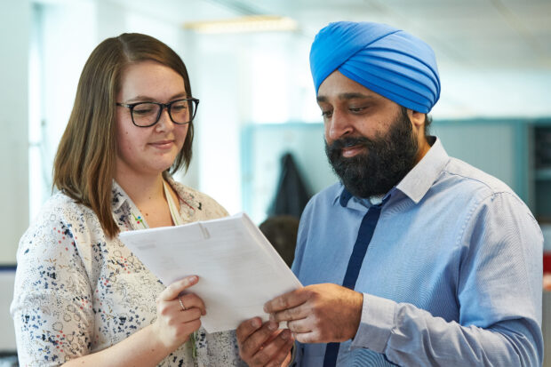 Man and woman looking at and holding a document.