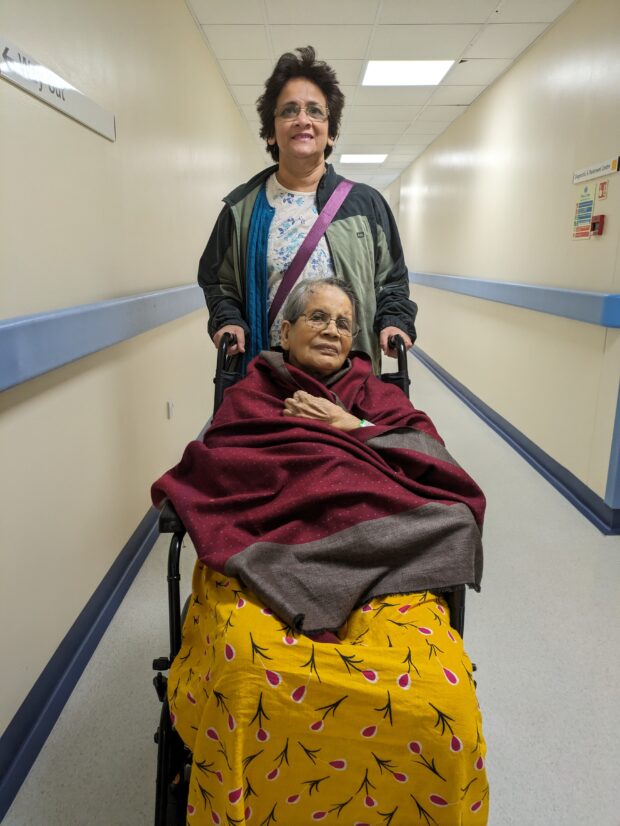 Sree pushing her mother in a wheelchair 